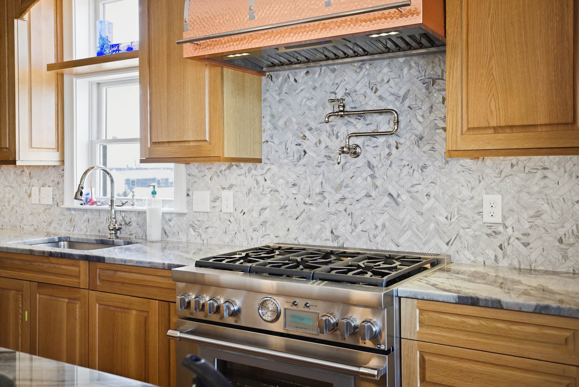 Pro gas range with hammered copper hood, pot filler, herringbone marble backsplash - Essex County MA