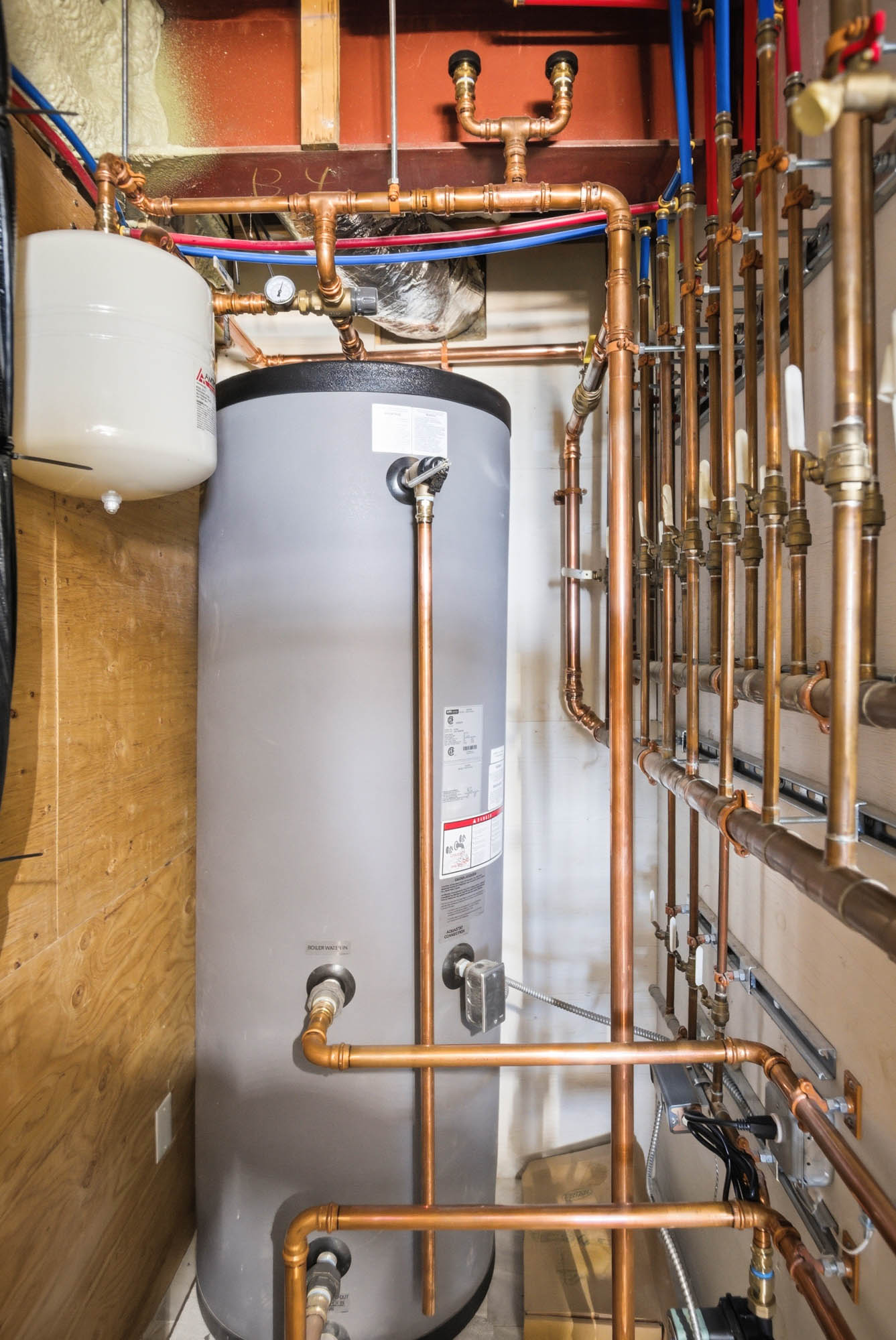 Mechanical room with indirect hot water tank and custom copper piping - hydronic heating