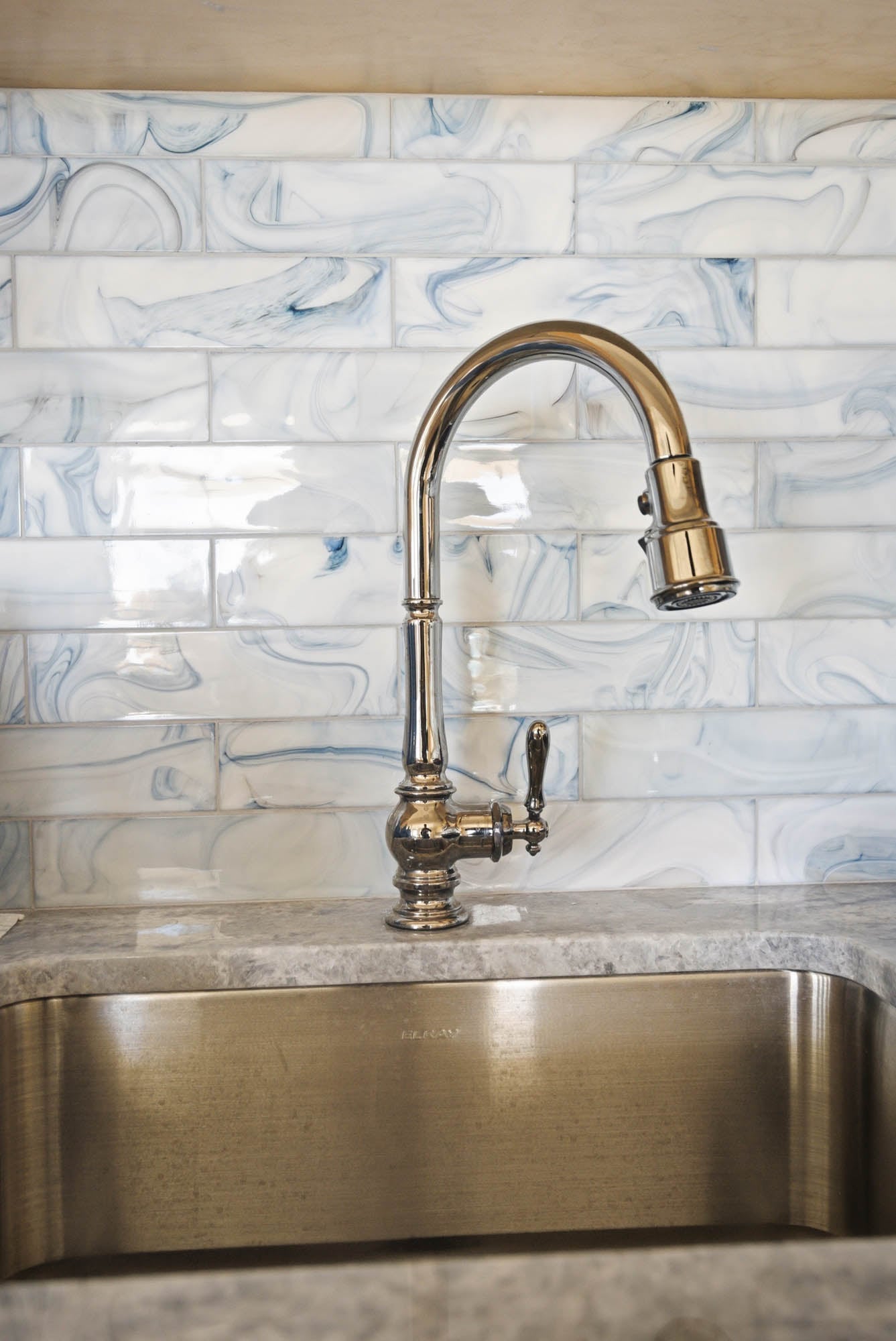 Polished nickel pull-down kitchen faucet over stainless apron sink - kitchen plumbing