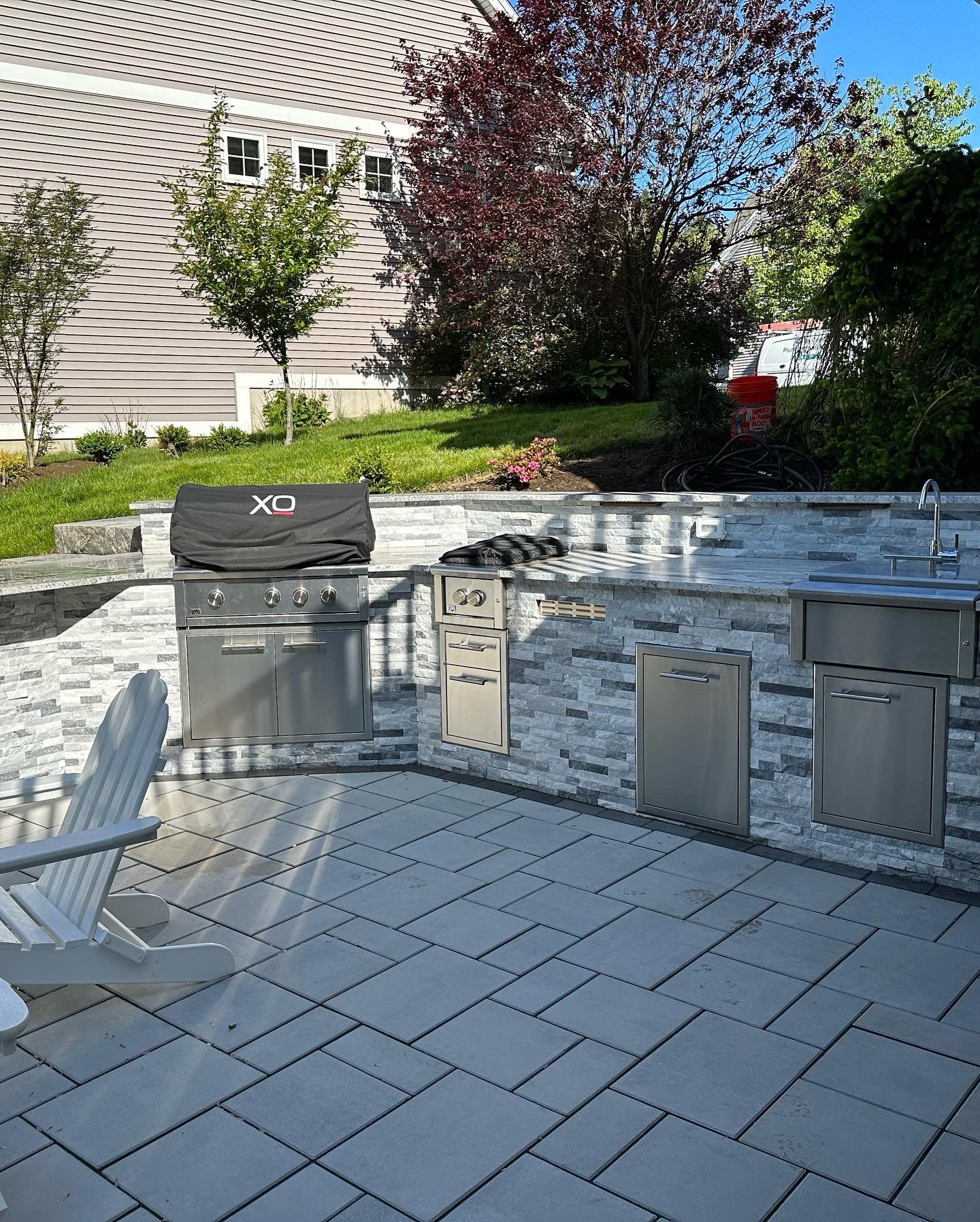 Outdoor kitchen close-up with gas grill and stone counters, Essex County MA installation